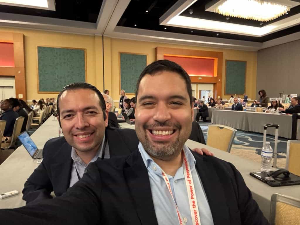 Two members share a selfie during a conference session