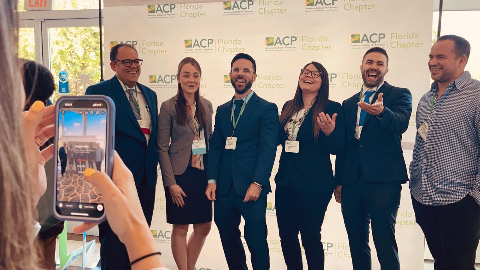 Members posing together in front of the ACP Florida Chapter backdrop