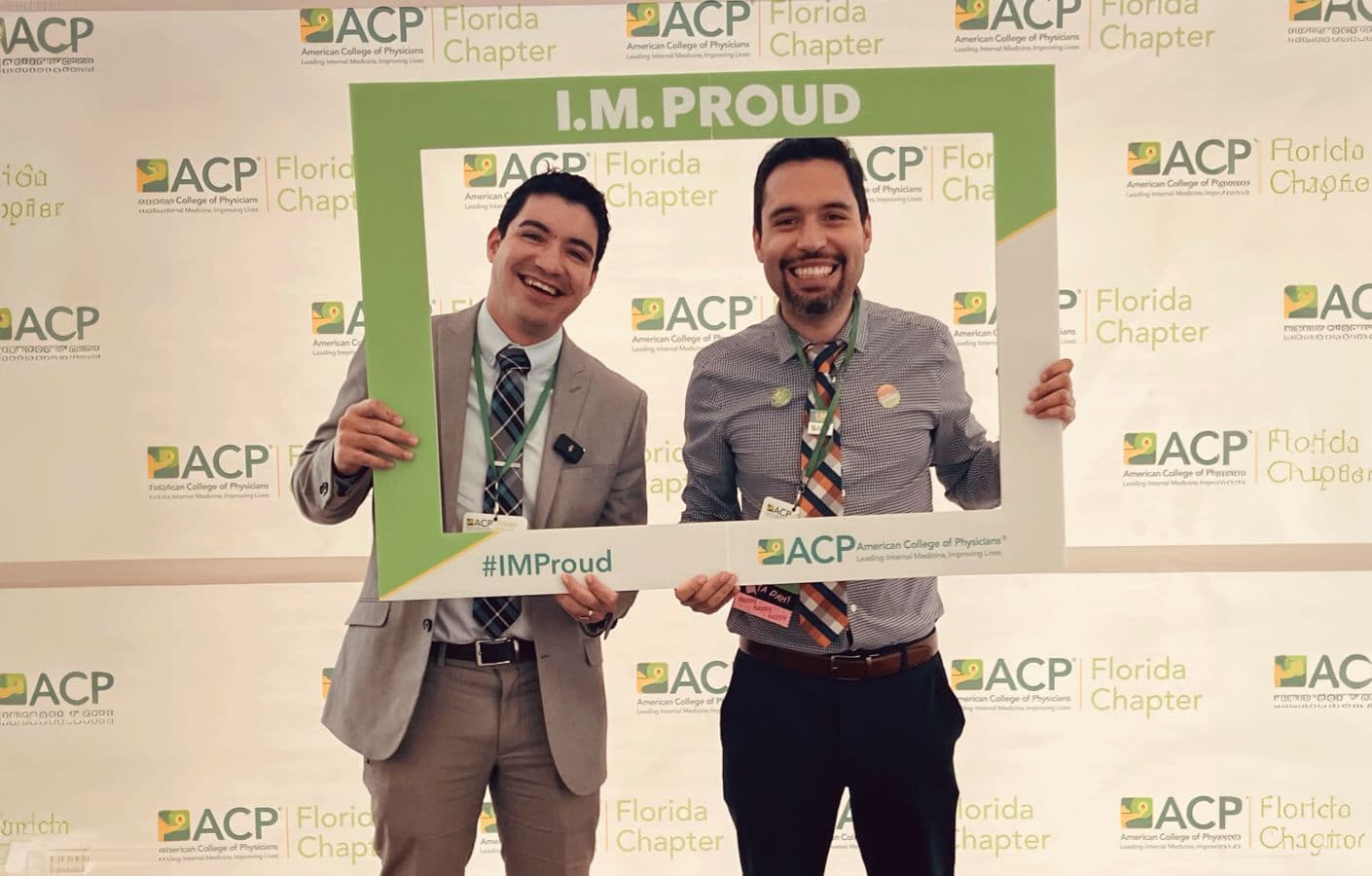 Two physicians holding the I.M. Proud photo frame