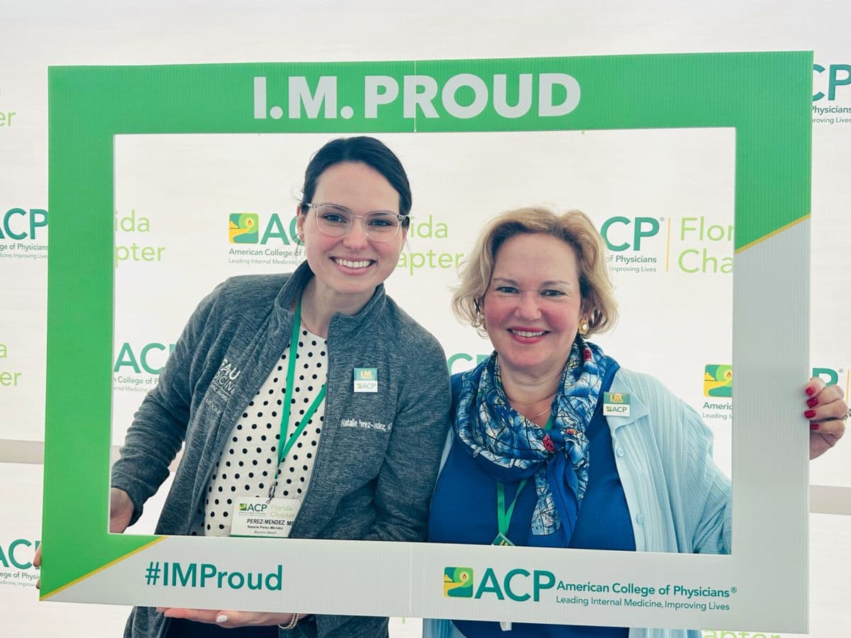 Two members smiling inside the I.M. Proud photo frame