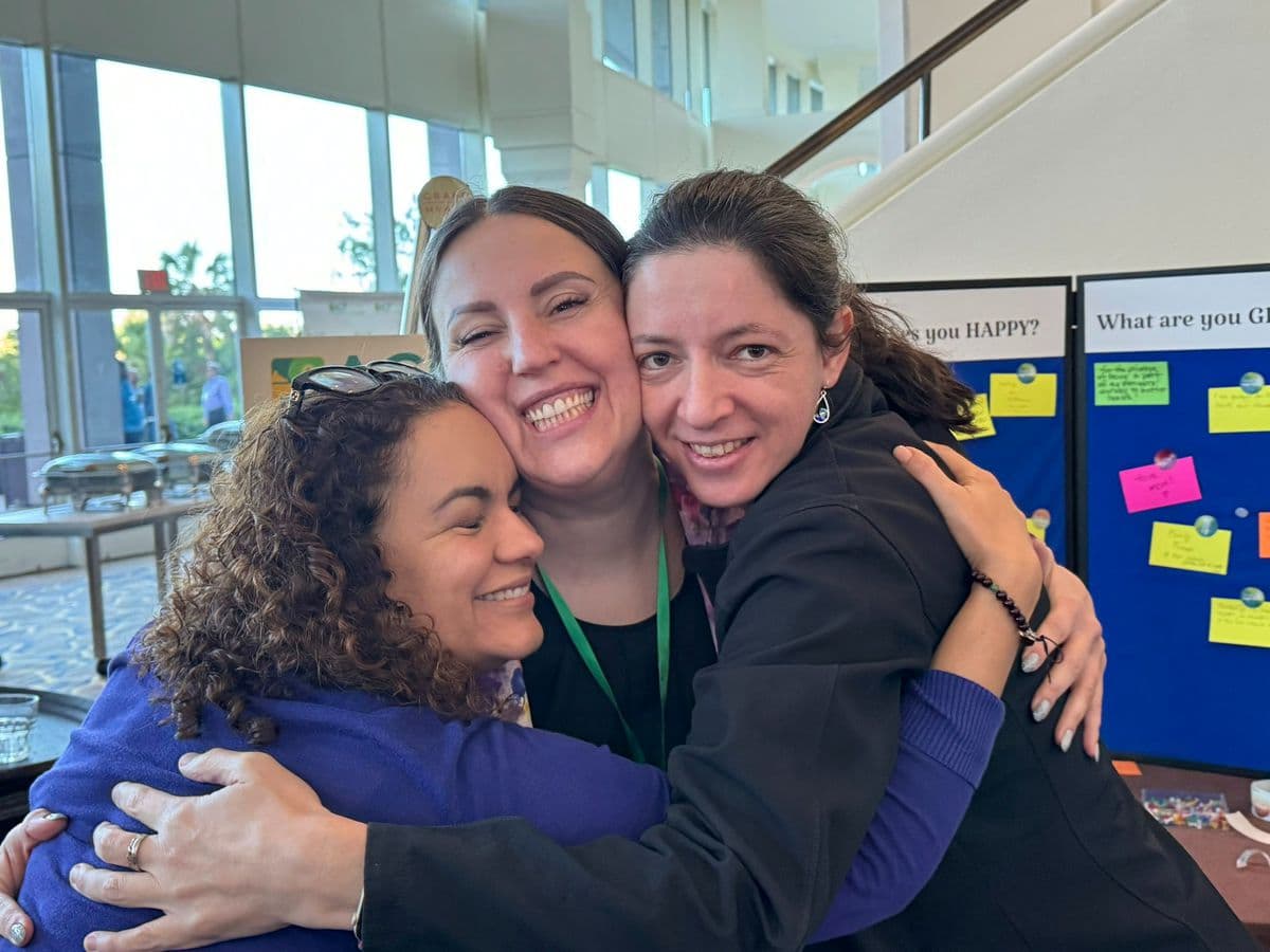 Three members embracing and laughing at a chapter event